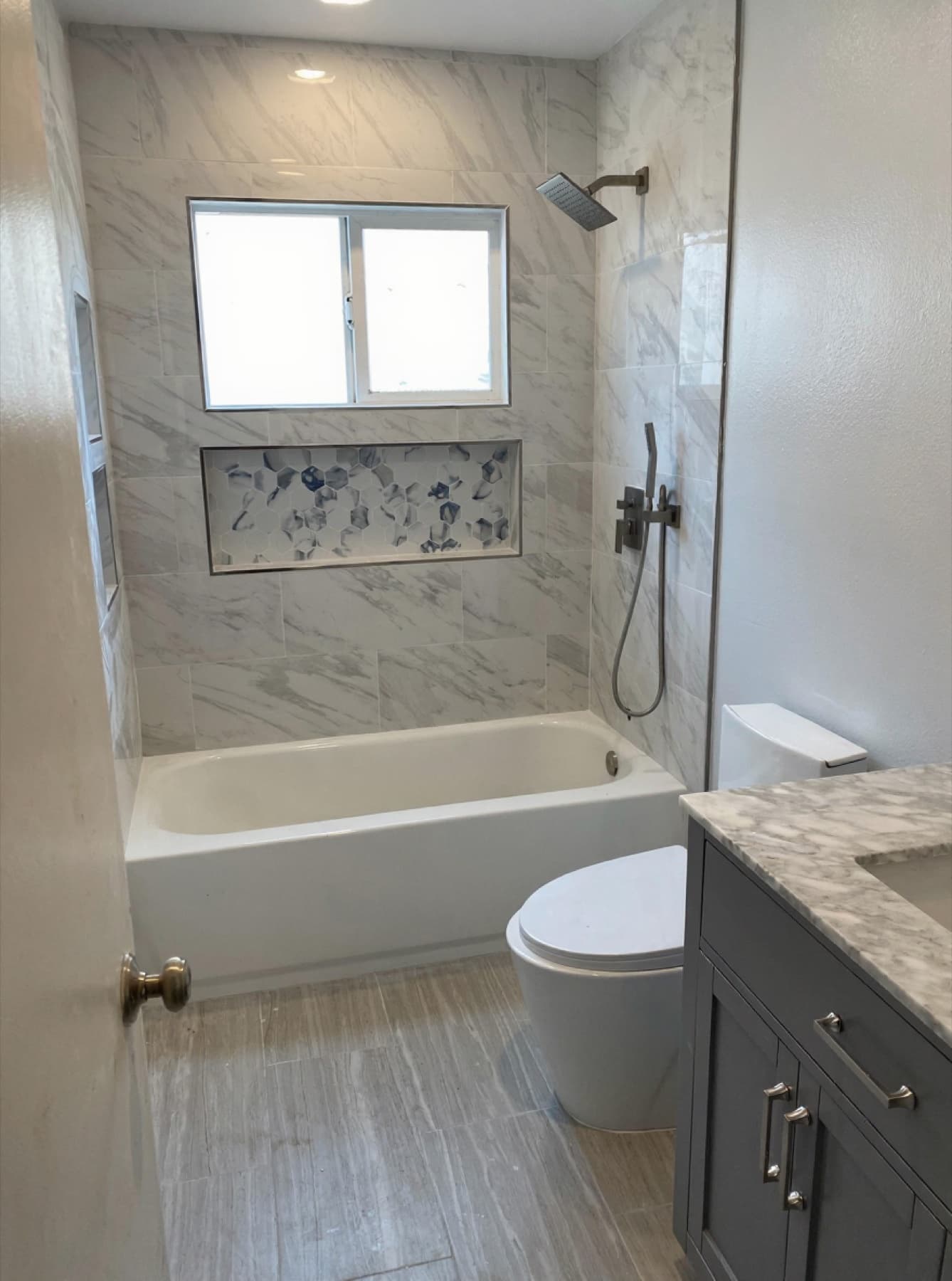 Marble bath suite with hex-mosaic niche
