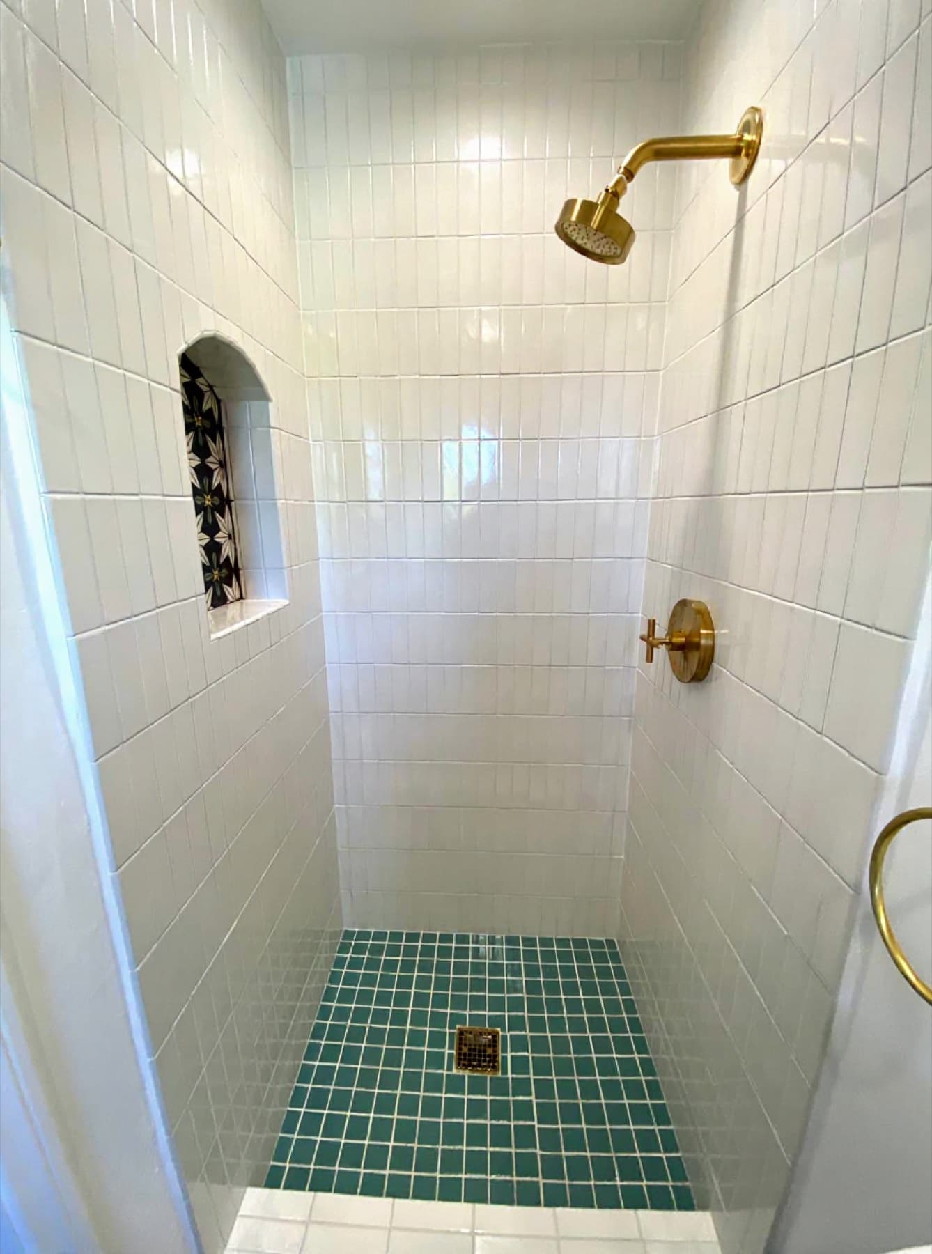 Vertical subway shower with brass + medallion niche