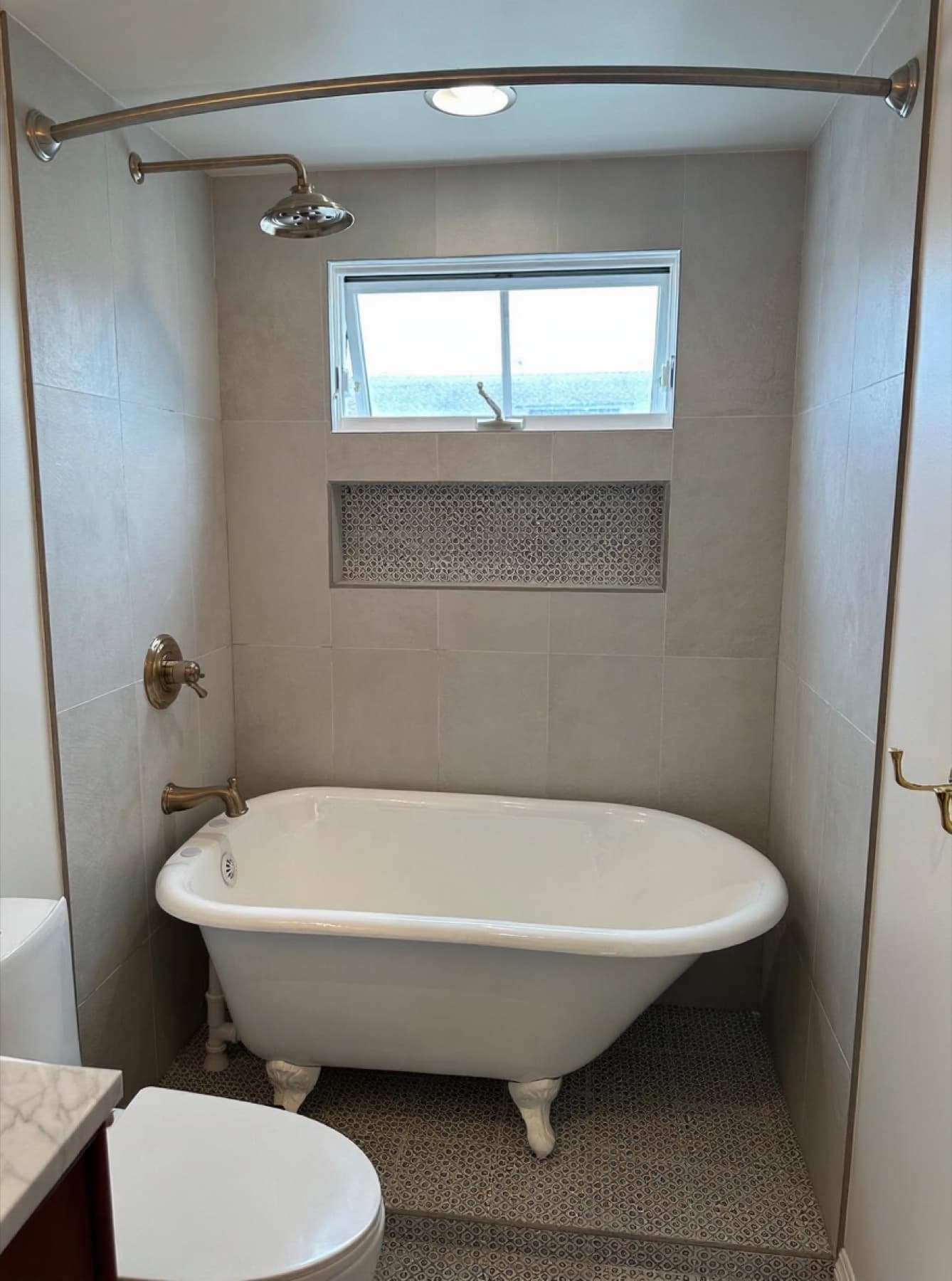 Clawfoot tub with patterned-mosaic shower niche