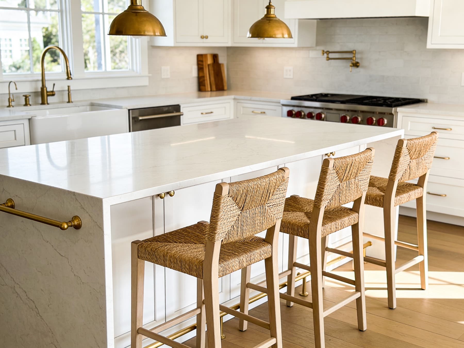 Kitchen island detail with brass hardware and woven stools